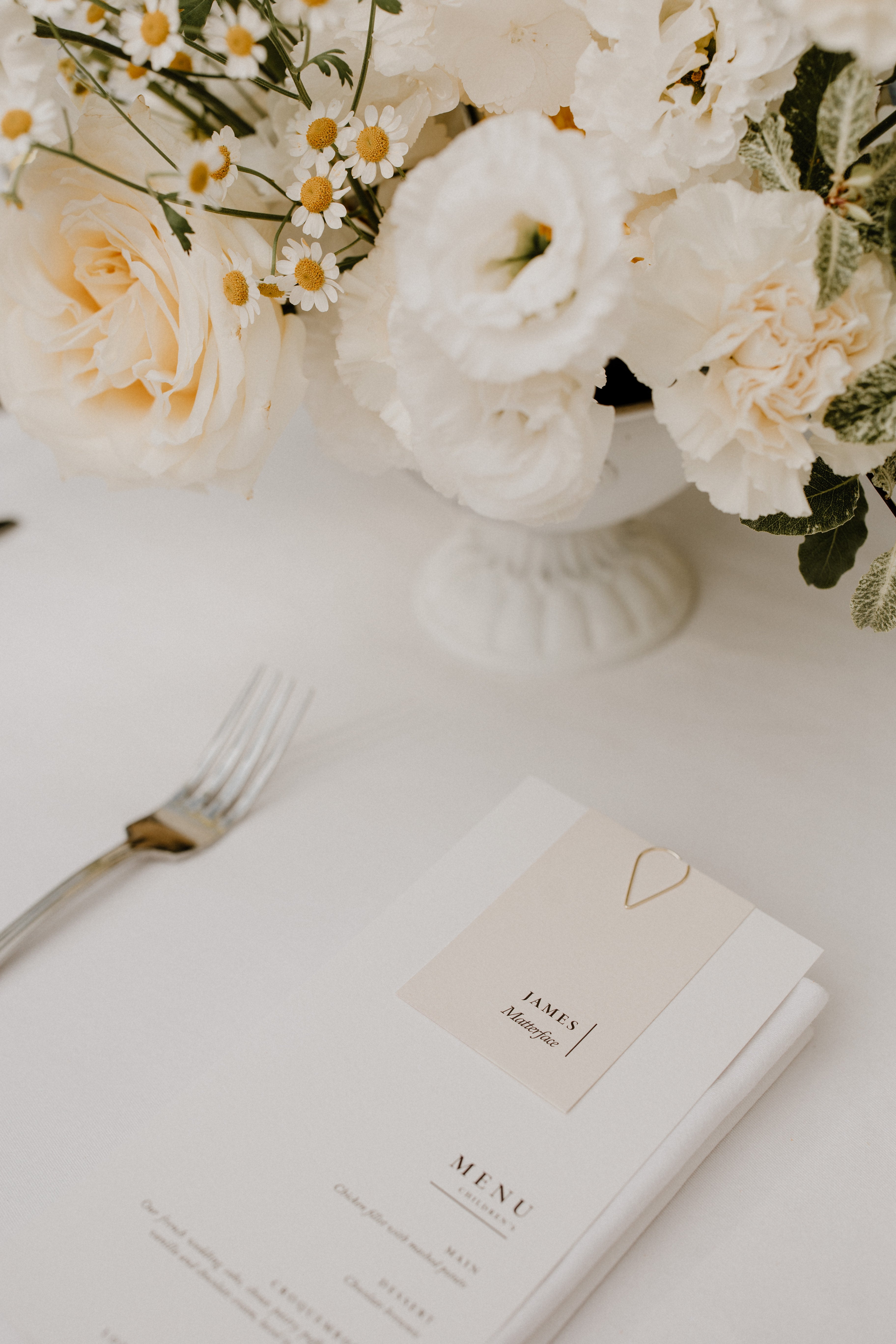 Lavender Muse wedding menu on wedding table with floral arrangement