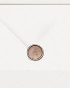 Bronze wax seal on wedding envelope with embossed rose vine