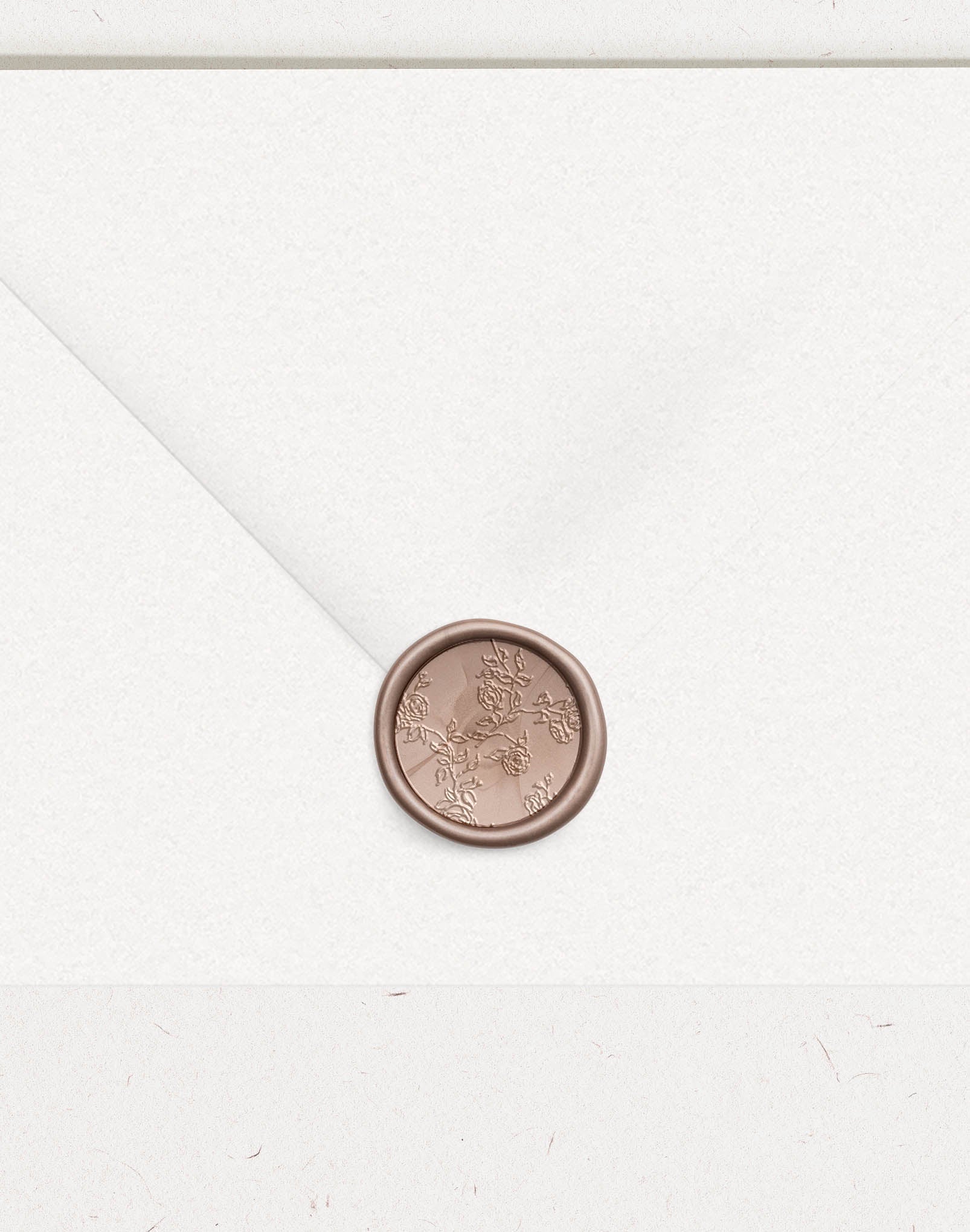 Bronze wax seal on wedding envelope with embossed rose vine