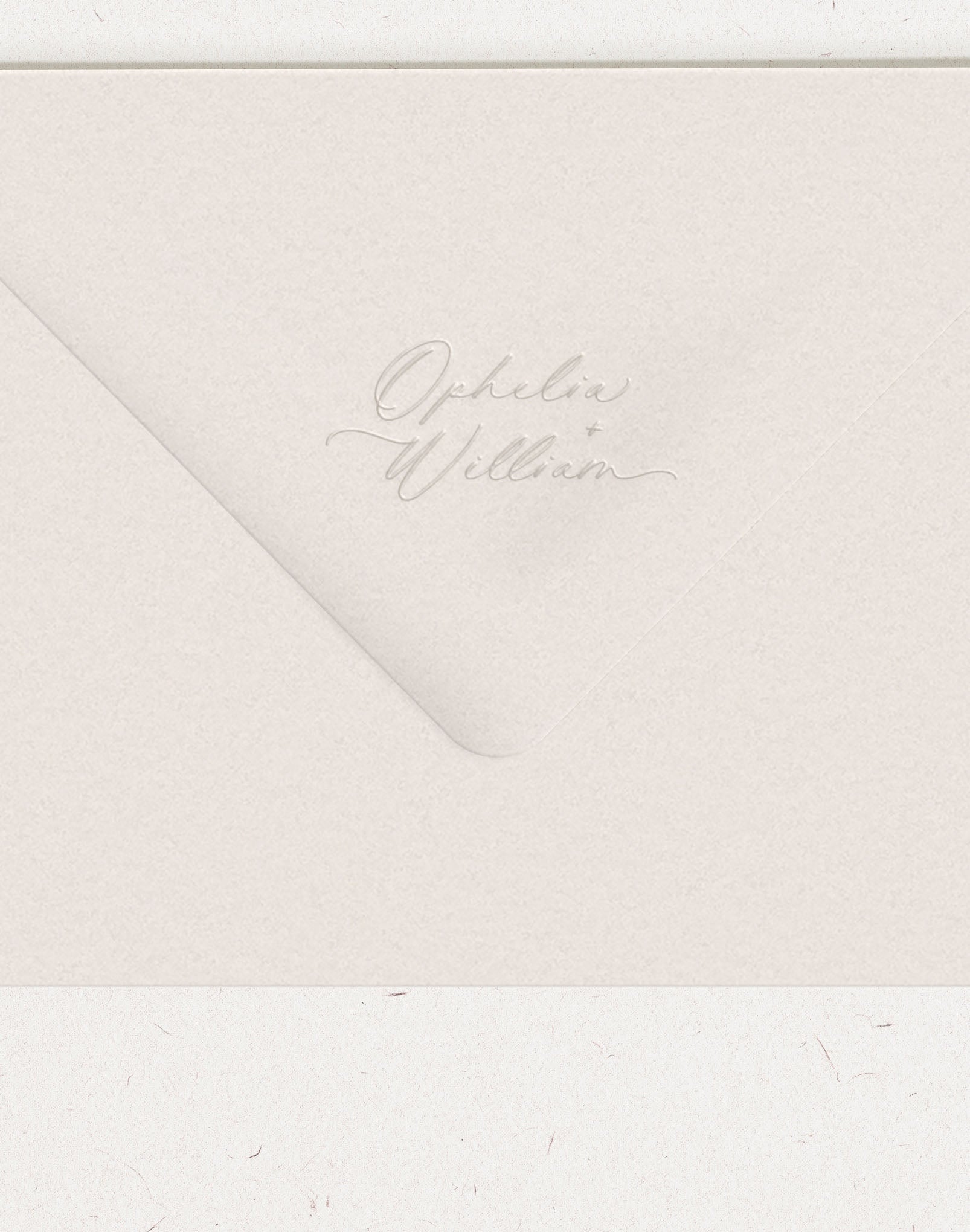 Script font names embossed on wedding envelope flap