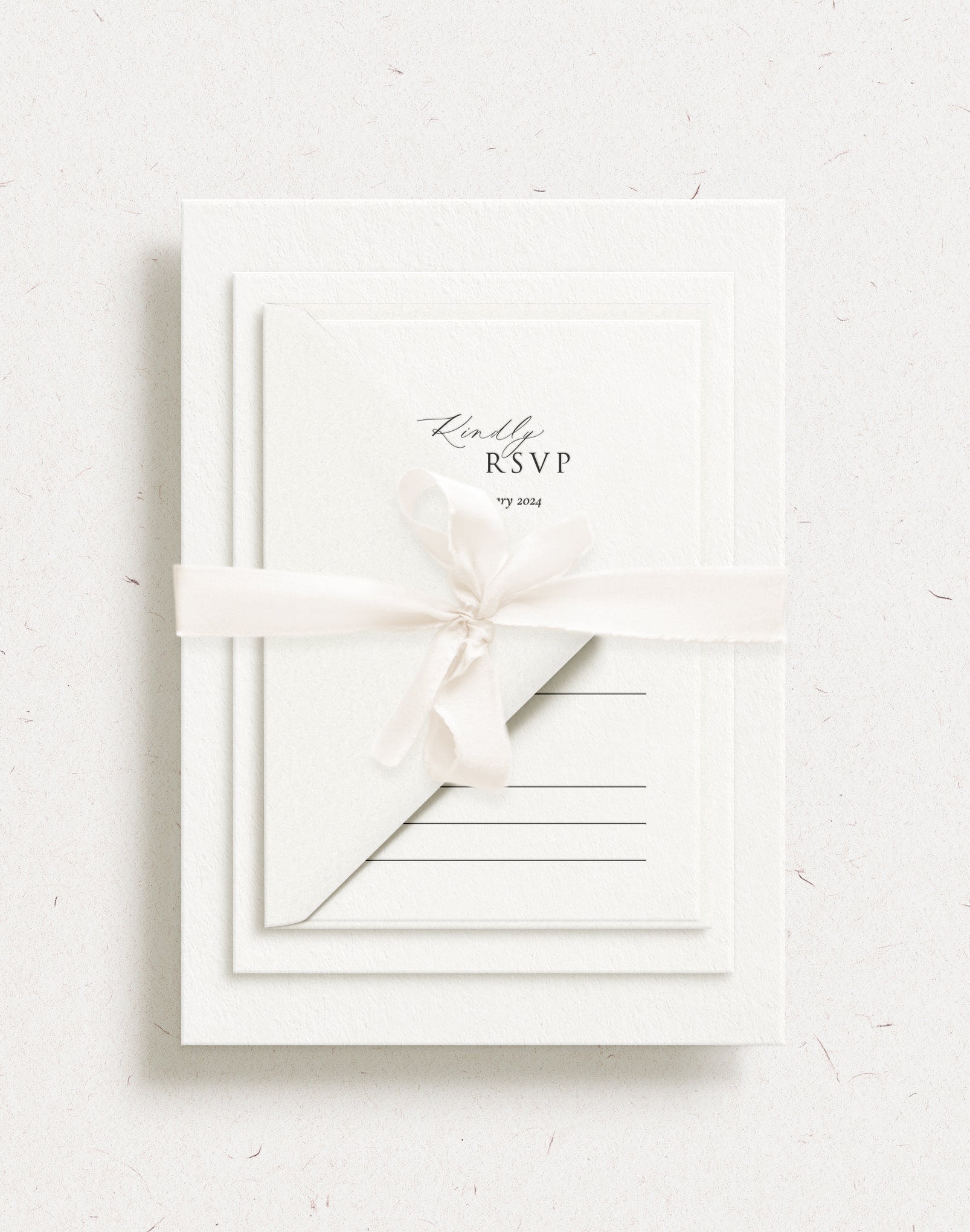 Luxury habotai silk ribbon in champagne colour, tied in a bow around a classic letterpress wedding invitation suite