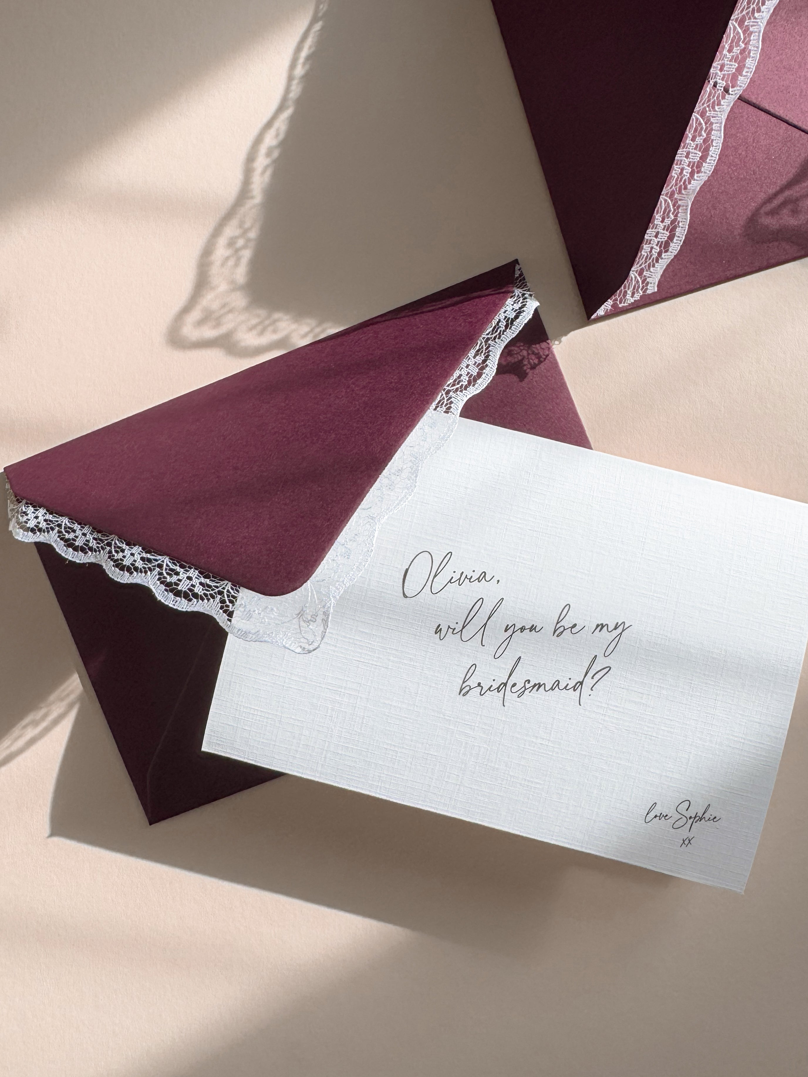 Vintage Inspired Burgundy Envelope with Lace Trim pairs with a personalised bridesmaid proposal card on linen textured card and handwritten script font.