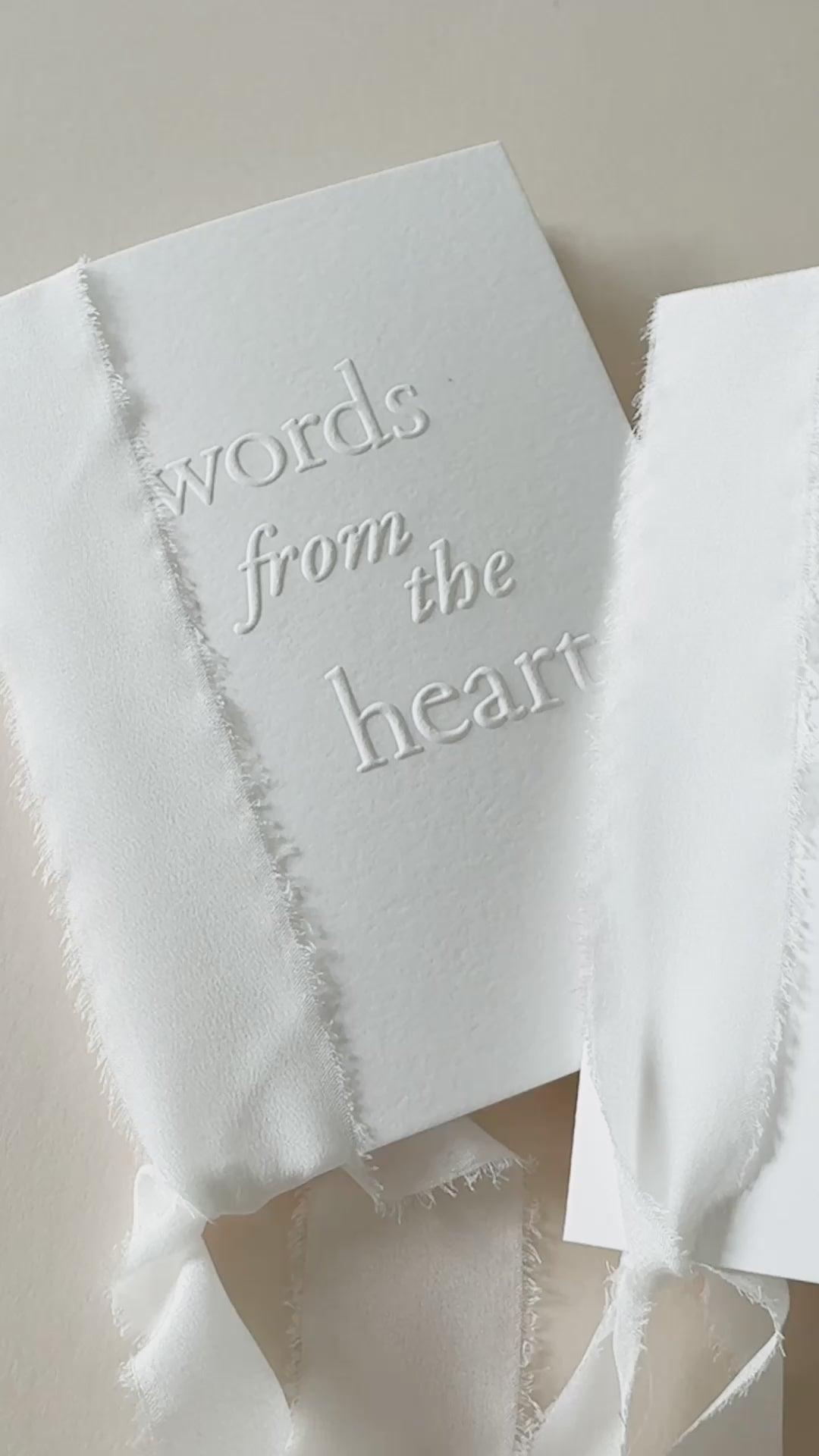 Video showing handmade speech books made from white cotton card, bound with white silk ribbon with the words 'words from the heart' embossed on the front cover. Perfect for wedding speeches, ceremony readings or love letters.
